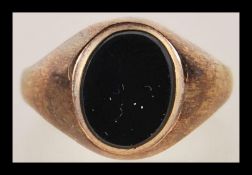 A 9ct gold hallmarked signet ring, set with an unmarked black cabochon stone. Size M, Gross weight