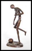 A 20th Century cast bronze figurine of a pre war footballer, the footballer in the action kicking