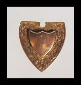 A hallmarked 9ct gold fob medal having an unmarked armorial shield with floral engraving to the