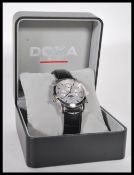 A cased gents Doxa moon-phase wrist watch, the silvered dial with moon-phase movement, baton markers