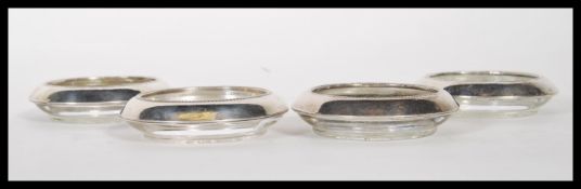 A set of four 20th Century Frank. M. Whiting and Co silver and glass coasters, the silver tops