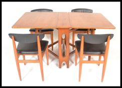 A retro 20th century teak wood drop leaf leg dining table together with a set of four matching