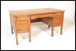 A mid century retro oak Air Ministry desk being raised on squared legs with pedestals of drawers
