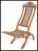 A 19th Century Victorian walnut folding campaign / nursing chair with carved and pierced top rail,