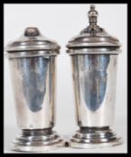A pair of silver hallmarked salt and pepper table cruets of tapering form raised on stepped round