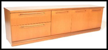 A mid century Danish inspired teak wood low credenza being raised on a plinth base with a series