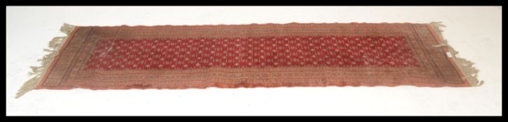 A vintage woolen Persian / Islamic floor rug runner set  on red ground,central panel with