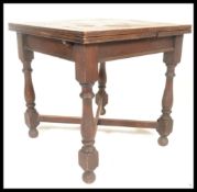 An early 20th century oak draw leaf dining table having,pull out leaves to each end being raised