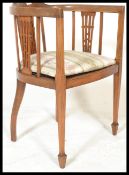 An Edwardian mahogany inlaid corner chair being raised on turned supports united by stretchers