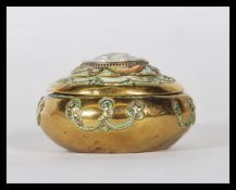 A 19th Century brass snuff pot, the hinged lid set with central carved cameo surrounded by a micro