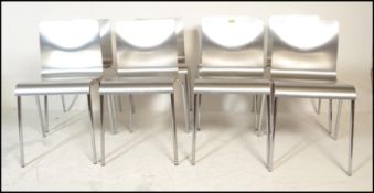A set of eight panel stacking dining  chairs, the chairs panels having a silvered finish raised on
