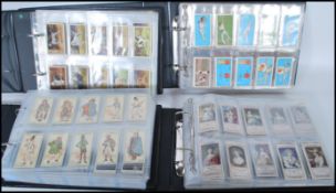 A group of four vintage cigarette cards to include military related cigarette cards such as Will'