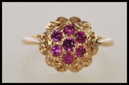 A hallmarked 9ct gold ladies dress ring set with seven pink stones to the head. Hallmarked London