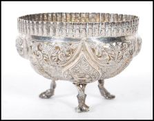 An Anglo Indian silver fret pierced dish raised on tripod feet, decorated in relief with fish and