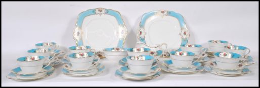 An early 20th Century Art Deco tea service by Royal Albert having blue ground borders with gilt