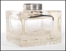 A silver hallmarked cut glass desk ink well having a silver cap inscribed 'Vincendo Victus' with a