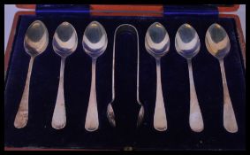 A cased set of 20th century silver hallmarked teaspoons and sugar tongs set complete in the original