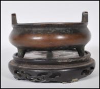 A 19th Century Chinese bronze censer ding bowl raised on tripod stubb feet with hoop handles and six