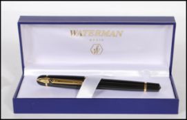 A cased Waterman ballpoint pen, the lidded pen having a black finish with gilt metal detailing in