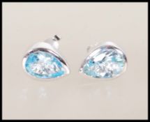 A pair of silver and blue topaz stud earrings each with post backs. The blue topaz in pear drop