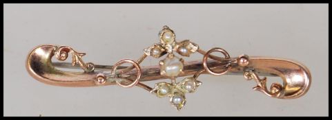 A hallmarked 9ct gold early 20th Century Edwardian bar brooch of scrolled form set with seven seed