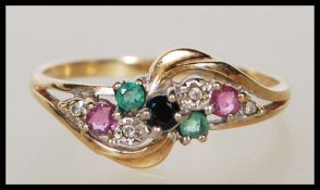 A hallmarked 9ct gold ring having a crossover design set with a cluster of round cut coloured stones