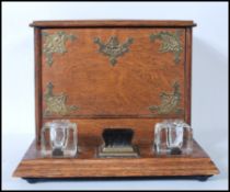 A 20th Century oak desk tidy having two glass inkwells to the base with brush between having