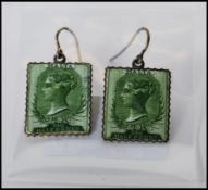 A pair of enamelled Victorian postage stamp earrings with Malta half penny stamps featuring Queen