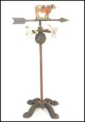 A vintage 20th Century cast iron painted weather vain being floor standing with quadruped weight