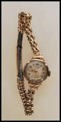 A vintage hallmarked 9ct gold ladies cocktail wrist watch by Avia, having an round white/ silvered