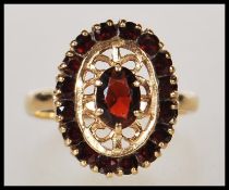 A hallmarked 9ct gold ladies dress ring having a pierced decoration oval head set with a central