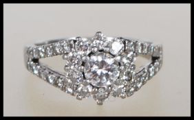A hallmarked 950 platinum and diamond Art Deco style ring. The central round brilliant cut diamond