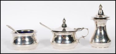 A silver hallmarked 3 piece condiment set to include lidded pot, open pot and pepperette. Blue glass