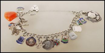 A vintage silver hallmarked charm bracelet having a heart lock with 17 charms to include a stalk,