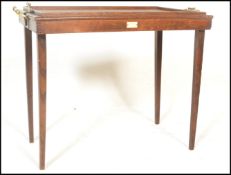 An early 20th Century oak metamorphic butlers tray / table having brass handles to each side with