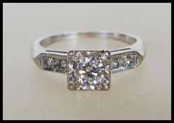 A 14ct white gold and diamond Art Deco style ring. The ring with central brilliant cut diamond