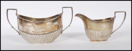 A near matching silver hallmarked sugar bowl and creamer set. The twin handled sugar bowl with