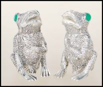 A pair of unusual salt and pepper condiments in the form of frogs having marcasite adorned eyes.