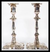 A pair of late 19th century silver candlesticks of rococo form being cast in relief and filled. Each
