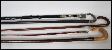 A collection of four walking stick canes to includ