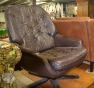 A vintage 1970's brown leather button back and seat leather armchair / swivel chair, having a five