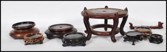 A collection of Chinese carved wooden vase stands / bases of different sizes and forms to include