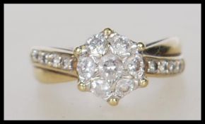 A stamped 9ct gold diamond cluster ring set with seven brilliant cut diamonds to the head, having