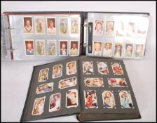 A group of three cigarette card albums including a selection of vintage filmstar cards such as