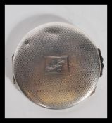 A silver hallmarked lroundel shaped ladies powder compact with inset mirror to the lid, powder