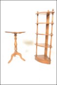 An Ercol circular  topped beech and elm wine table raised on turned supports above tripod base