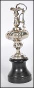 A silver hallmarked miniature amphora / ewer cast in relief and raised on a wooden ebonised socle