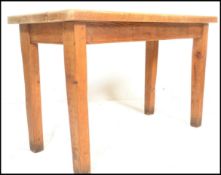 A vintage early 20th century chunky country pine scrub top dining table being raised on squared legs