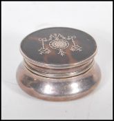 An early 20th Century William Comyns & Sons Ltd silver pill box of round form having a tortoise