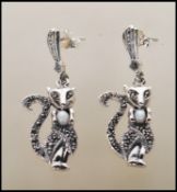 A pair of silver marcasite and opal earrings in the form of cats having mother of pearl cabochon